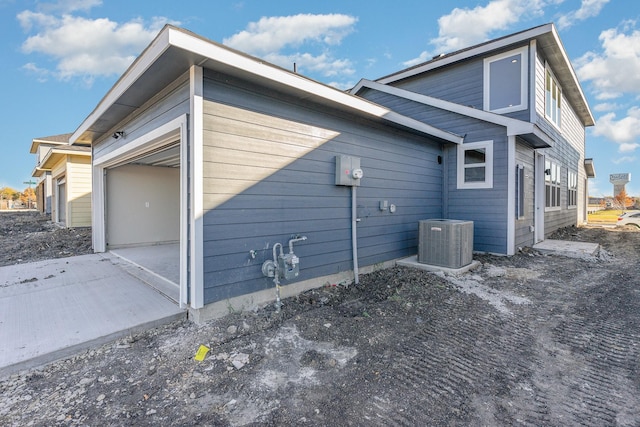 view of home's exterior with a garage and central air condition unit