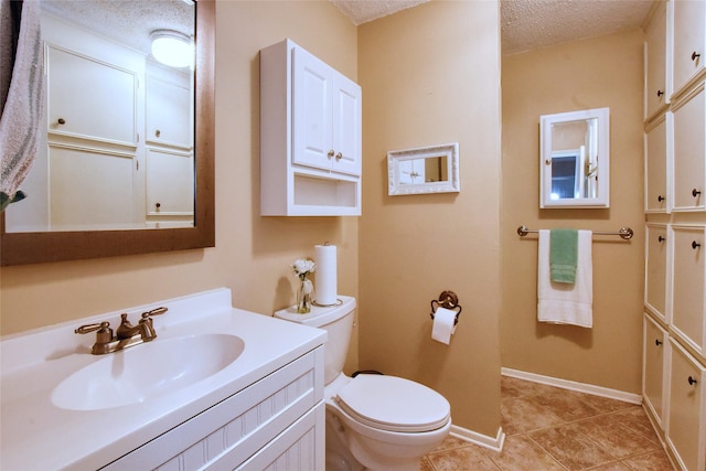 bathroom featuring tile patterned floors, vanity, a textured ceiling, and toilet