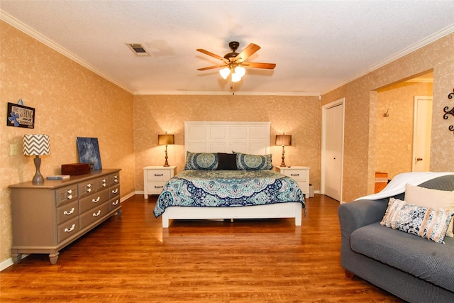 bedroom featuring a textured ceiling, hardwood / wood-style flooring, ceiling fan, and ornamental molding