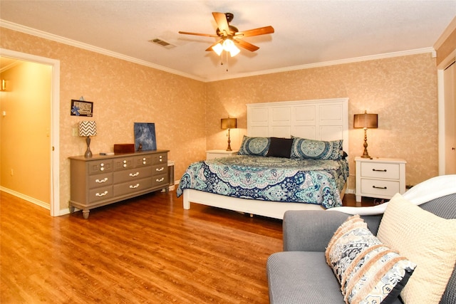 bedroom featuring crown molding, ceiling fan, and wood-type flooring