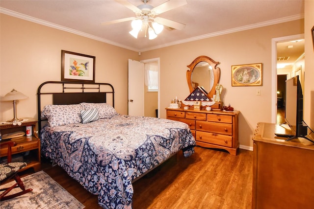 bedroom with hardwood / wood-style flooring, ceiling fan, and crown molding