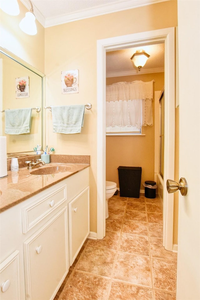 bathroom featuring crown molding, vanity, a shower with shower door, and toilet