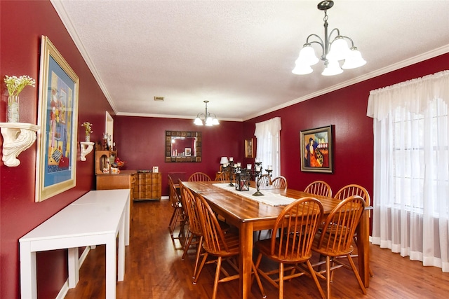 dining room with hardwood / wood-style flooring, crown molding, a wealth of natural light, and an inviting chandelier