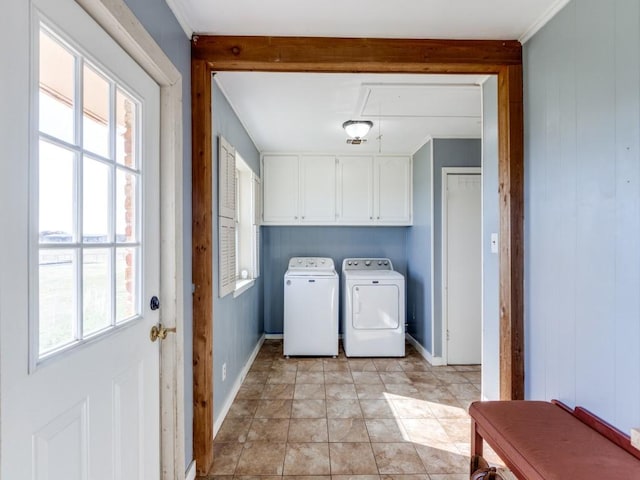 clothes washing area featuring wooden walls, light tile patterned flooring, cabinets, and washing machine and dryer