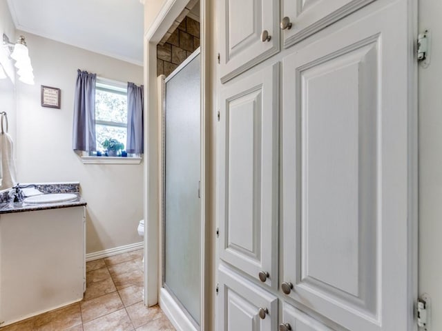 bathroom featuring crown molding, vanity, a shower with shower door, and toilet