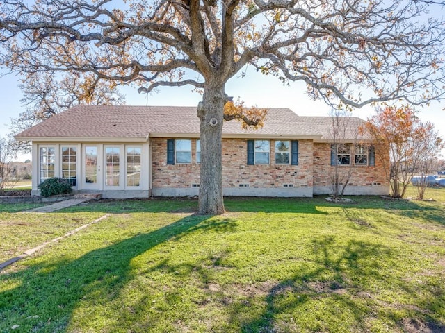 rear view of property featuring a lawn