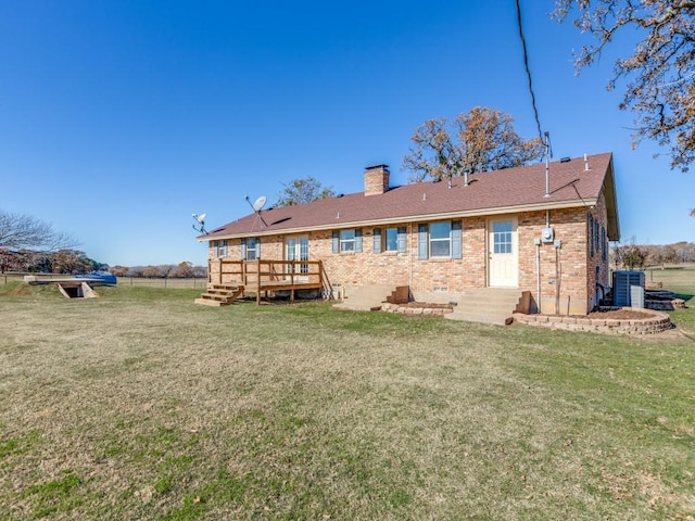 rear view of house with cooling unit, a deck, and a yard