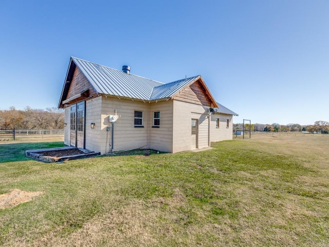 view of side of property featuring a yard and a rural view