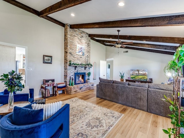 living room with a fireplace, wood-type flooring, lofted ceiling with beams, and ceiling fan