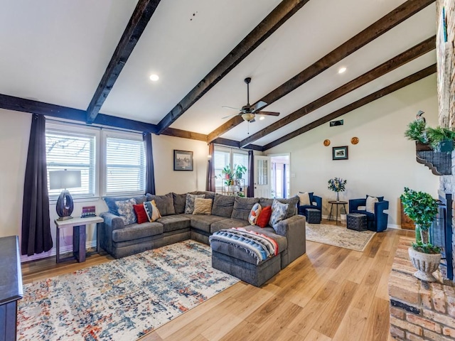 living room with ceiling fan, plenty of natural light, light hardwood / wood-style floors, and lofted ceiling with beams