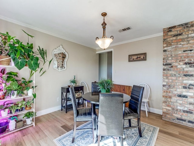 dining area with crown molding and light wood-type flooring