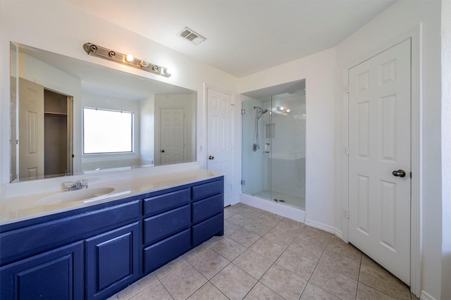 bathroom featuring tile patterned flooring, vanity, and walk in shower