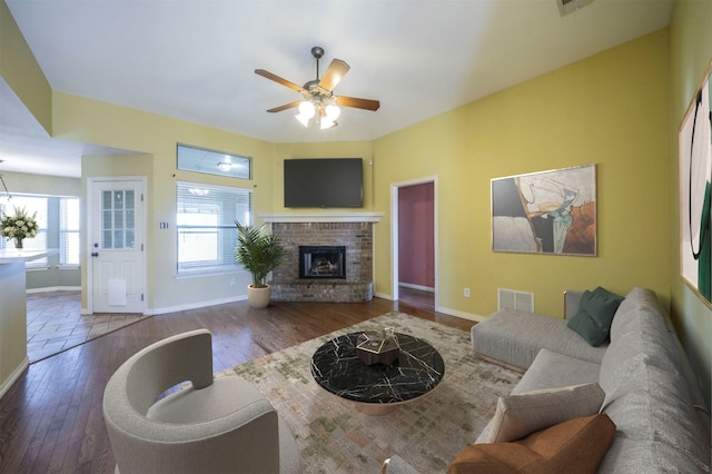 living room featuring a fireplace, hardwood / wood-style floors, and ceiling fan