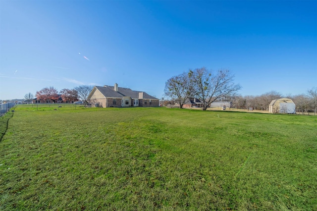 view of yard with a rural view and a storage shed