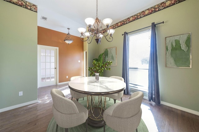 dining space featuring dark hardwood / wood-style flooring and a chandelier