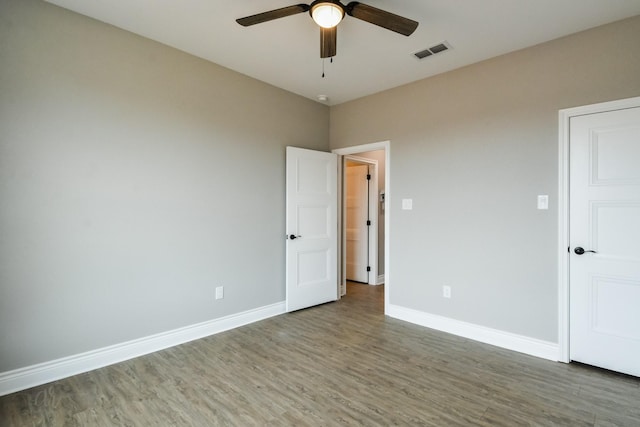 unfurnished bedroom featuring dark wood-type flooring and ceiling fan