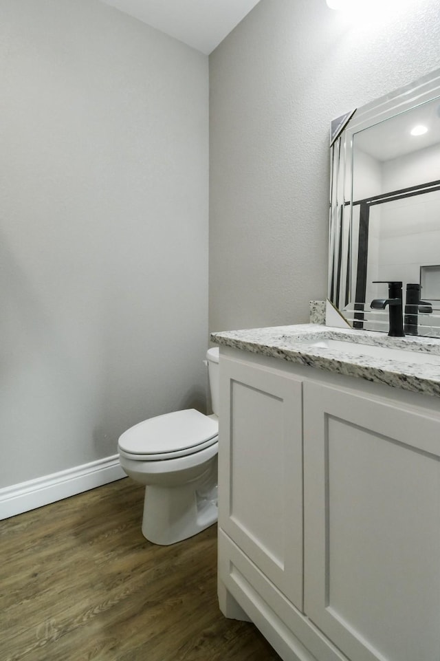 bathroom featuring vanity, hardwood / wood-style floors, and toilet