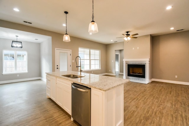 kitchen with sink, hanging light fixtures, dishwasher, an island with sink, and white cabinets