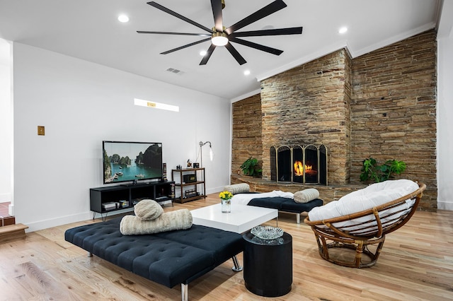 living room featuring ceiling fan, light wood-type flooring, and vaulted ceiling