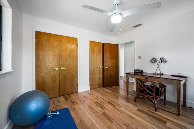 exercise room featuring ceiling fan and light wood-type flooring