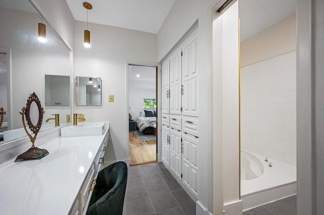 bathroom with tile patterned flooring, vanity, and a washtub