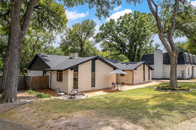 back of house with a yard and a patio