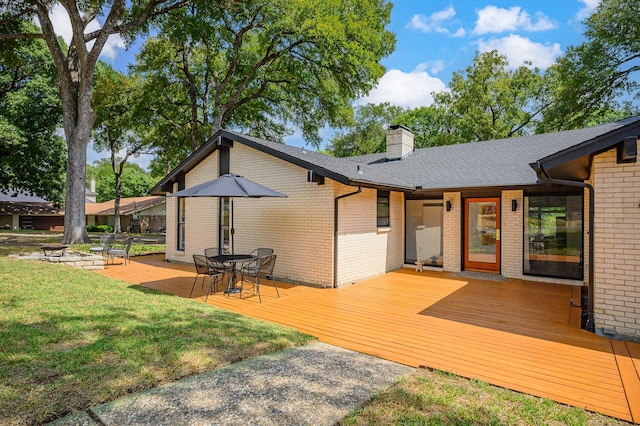 rear view of property featuring a lawn and a wooden deck