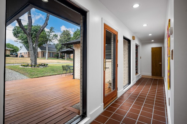 hall featuring dark tile patterned flooring