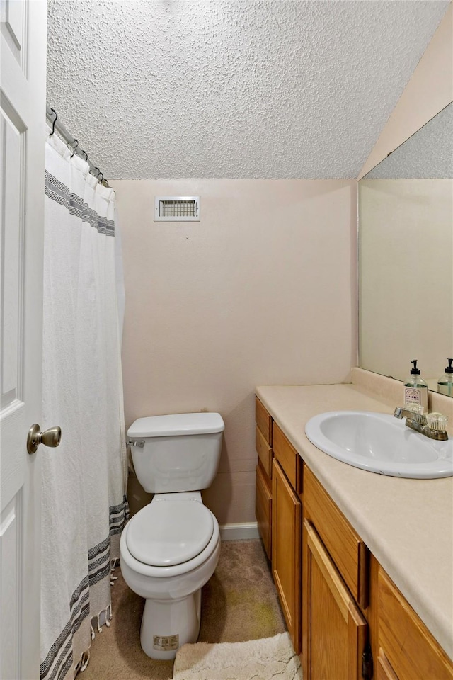 bathroom with vanity, vaulted ceiling, toilet, and a textured ceiling