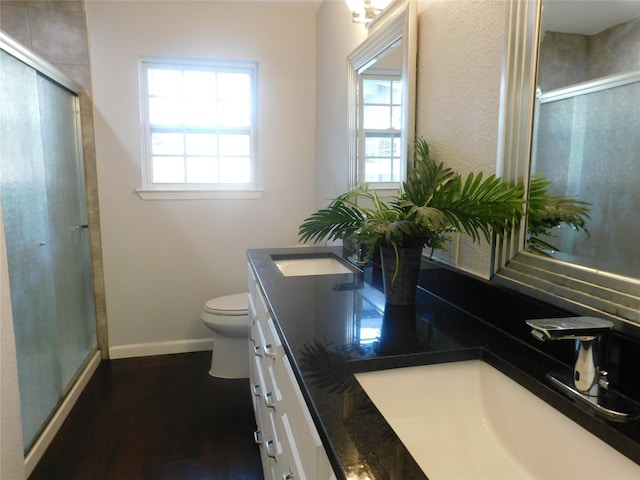 bathroom with toilet, a wealth of natural light, hardwood / wood-style floors, and walk in shower