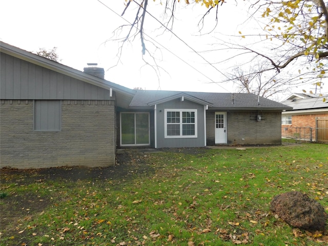 rear view of property with a lawn