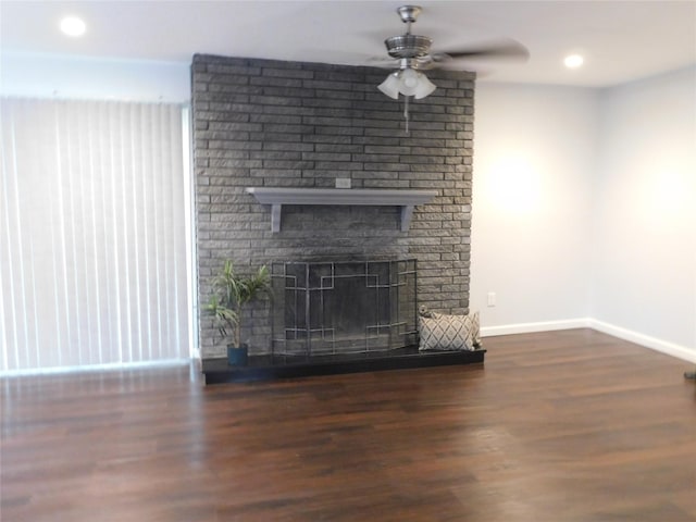 unfurnished living room featuring ceiling fan, dark hardwood / wood-style floors, and a brick fireplace