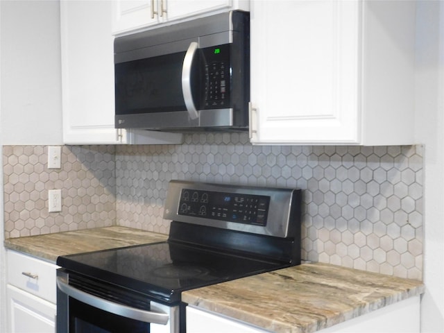 kitchen featuring decorative backsplash, white cabinets, and stainless steel appliances