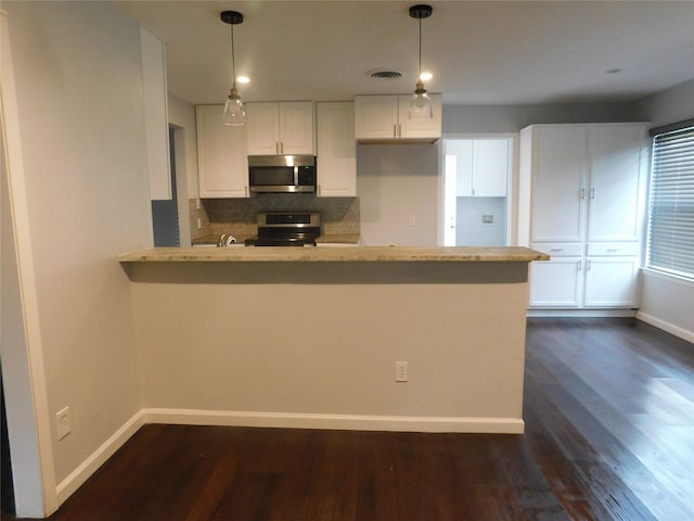 kitchen featuring stainless steel appliances, dark hardwood / wood-style flooring, kitchen peninsula, pendant lighting, and white cabinets