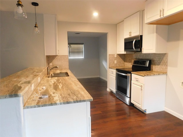 kitchen featuring white cabinetry, sink, hanging light fixtures, dark wood-type flooring, and appliances with stainless steel finishes