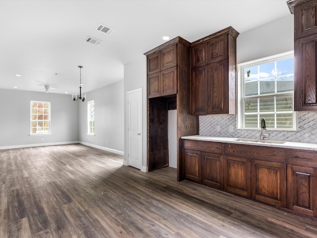 kitchen featuring backsplash, dark hardwood / wood-style floors, sink, and a wealth of natural light