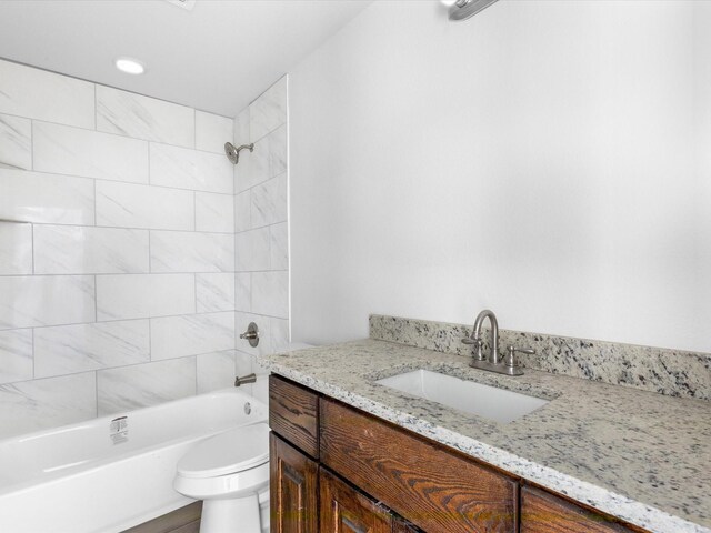 full bathroom featuring toilet, vanity, and tiled shower / bath