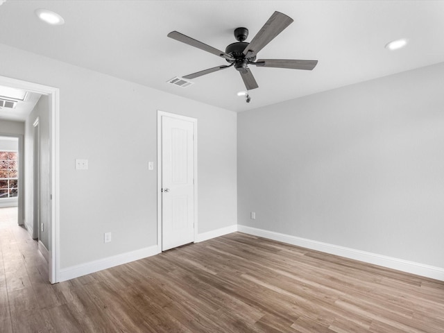 empty room with hardwood / wood-style floors and ceiling fan