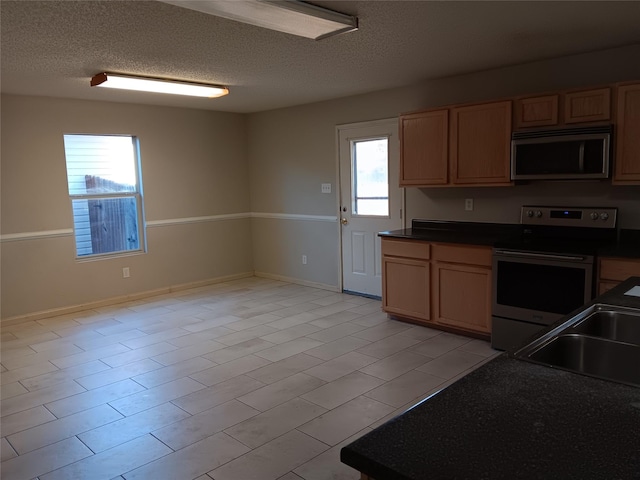 kitchen with sink, stainless steel appliances, and a textured ceiling