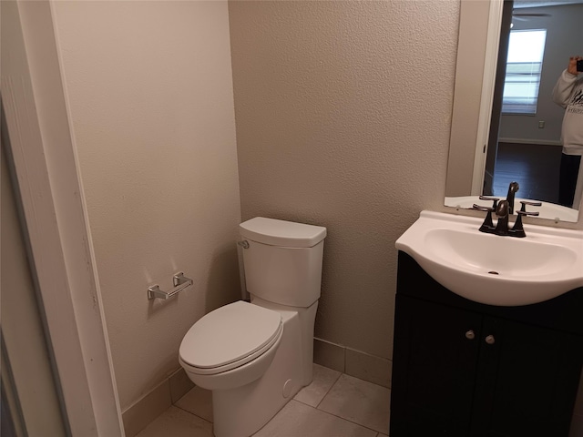 bathroom featuring vanity, tile patterned flooring, and toilet