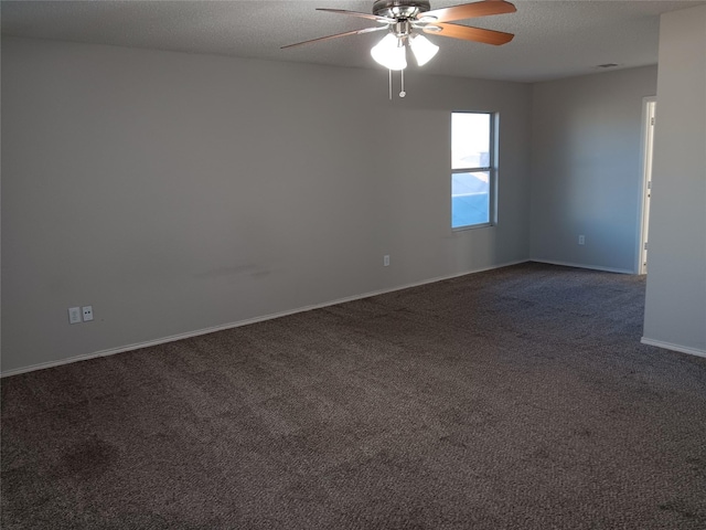 carpeted empty room featuring ceiling fan and a textured ceiling