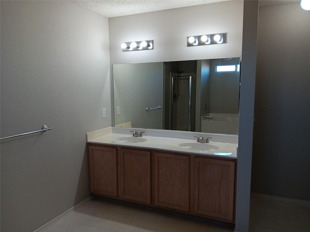 bathroom with plus walk in shower, vanity, and a textured ceiling