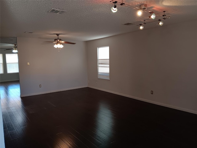 unfurnished room with dark wood-type flooring, ceiling fan, rail lighting, and a textured ceiling