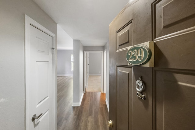 hall featuring dark wood-style floors and baseboards