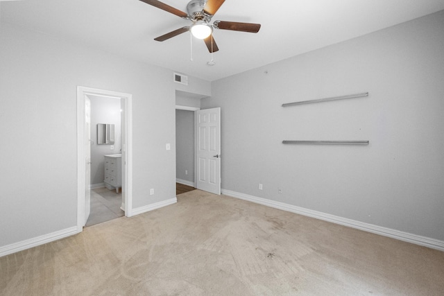 unfurnished bedroom featuring a ceiling fan, baseboards, visible vents, ensuite bath, and carpet flooring