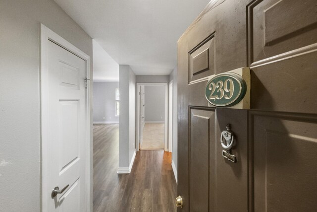 corridor with dark hardwood / wood-style flooring