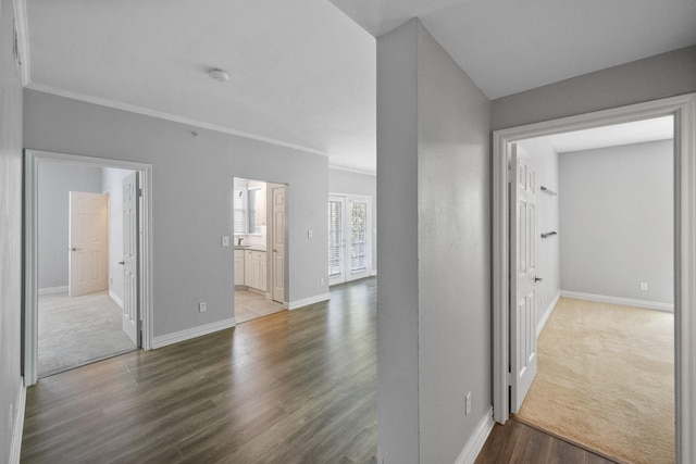 hall with wood-type flooring and ornamental molding