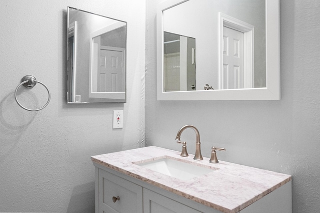 bathroom featuring vanity and a textured wall