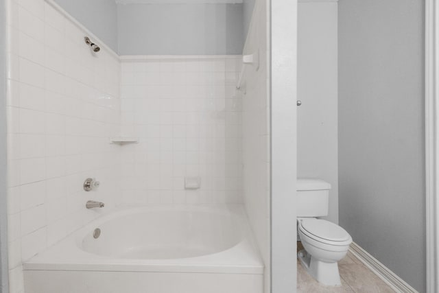 bathroom with tile patterned floors, toilet, bathing tub / shower combination, and baseboards