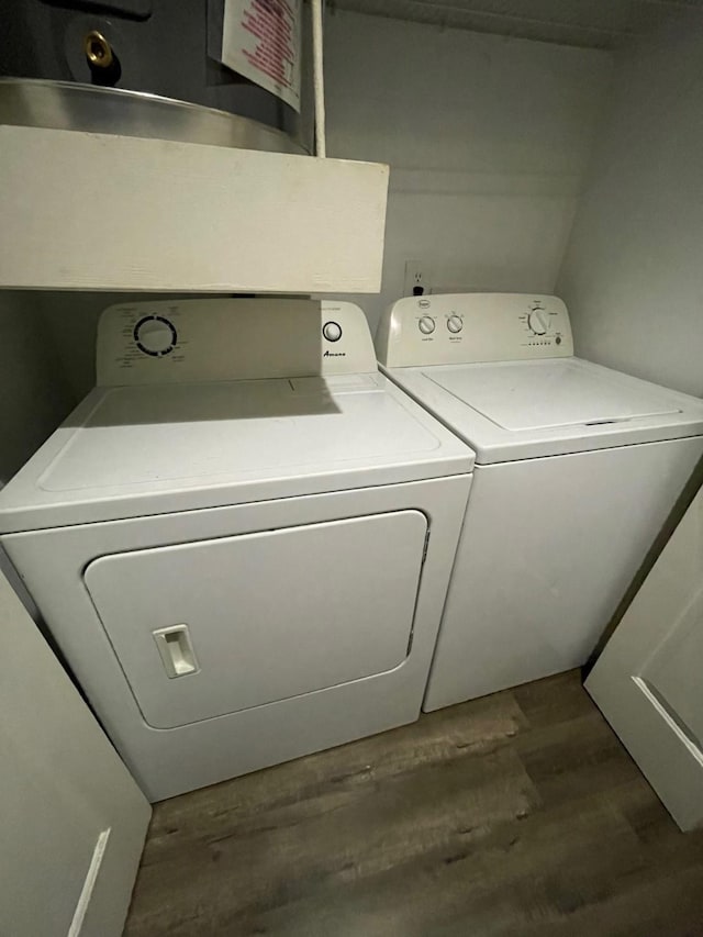 clothes washing area featuring laundry area, washing machine and dryer, and dark wood-style flooring